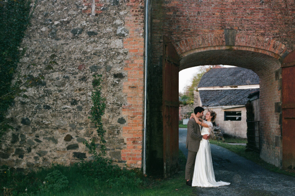 Editorial couple beneath a brick arch at Hilton Park